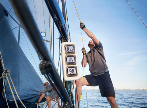 sailor pulling on lines to hoist sails